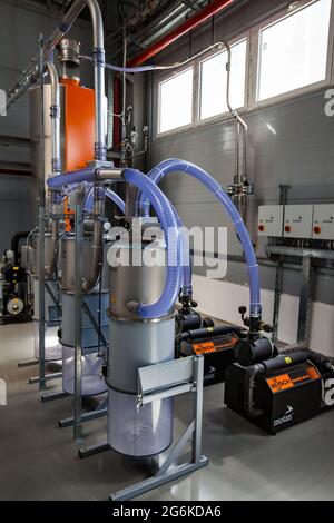 Atyrau,Kazakhstan: Chevron plant. Plastic pipes modern production line close up photo. Grey metal equipment, blue transparent corrugated s Stock Photo