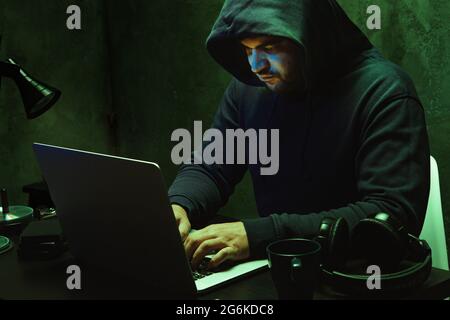 Hacker programmer using computer in dark room Stock Photo