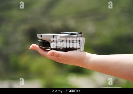Modern small compact quadcopter in a girl's hand. Launching a drone from your hand Stock Photo