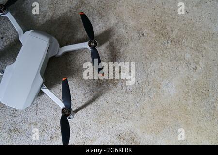 Small gray quadcopter on a gray background. Quadrocopter close-up. Stock Photo