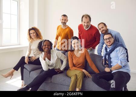 People group of different age and ethnicity sitting on sofa looking at camera Stock Photo