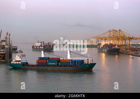 Very early morning at busy Barcelona Harbour. Container ship maneuvering .Spain Stock Photo