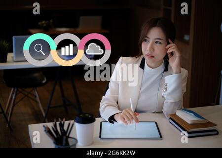 Young woman Accountant do audit tax of company by digital tablet in application on cloud with virtual icon on screen Stock Photo