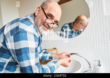 Craftsman as plumber repairing sink faucet in the bathroom Stock Photo