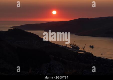 Sunrise over Porthills, Christchurch, Aotearoa New Zealand. The Port Hills are a 12 million-year-old remnant of the Lyttelton volcano crater. Wind, ra Stock Photo