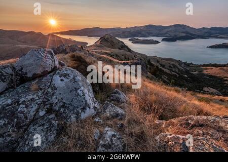 Sunrise over Porthills, Christchurch, Aotearoa New Zealand. The Port Hills are a 12 million-year-old remnant of the Lyttelton volcano crater. Wind, ra Stock Photo