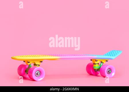 rainbow plastic Penny board skateboard isolated on pink background Stock Photo