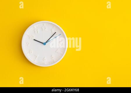 White wall Clock on yellow background. Stock Photo