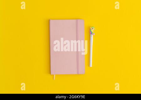 Notebook and pen on yellow background. Top view. Flat lay. Back to school concept. Stock Photo