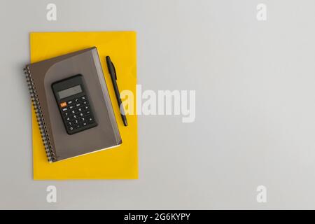 Calculator, notebook and pen on grey background Stock Photo