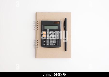 Calculator, notebook and pen on a white background Stock Photo