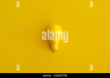 Light bulb on yellow background. Inspiration and creative idea concept. Top view with copy space. Flat lay composition. Stock Photo