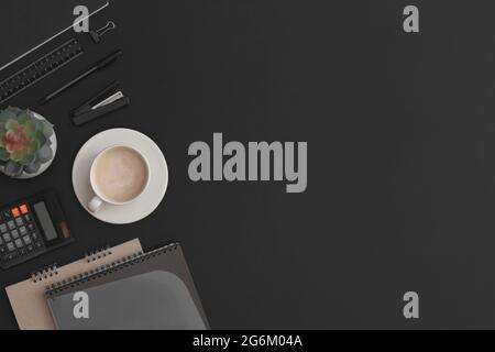 Black leather office table with calculator, notebook, coffee cup  and green plant. Top view with copy space. Flat lay composition. Stock Photo