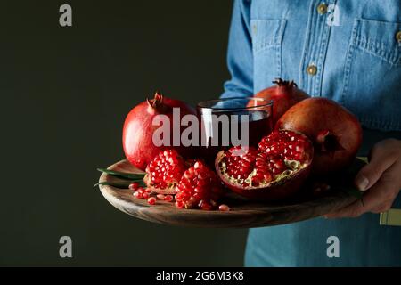 Woman holds tray with pomegranate juice and ingredients, close up Stock Photo