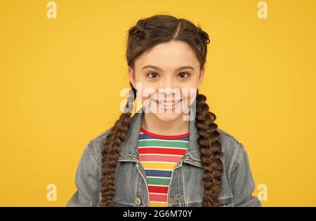 Happy little girl with braids wear denim clothes, fashion trend concept Stock Photo