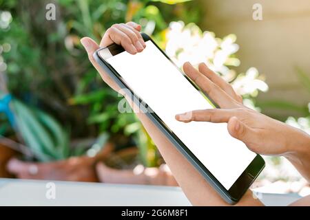 Woman's hand is touching on the white screen of the tablet, using technology and social media concepts. Stock Photo