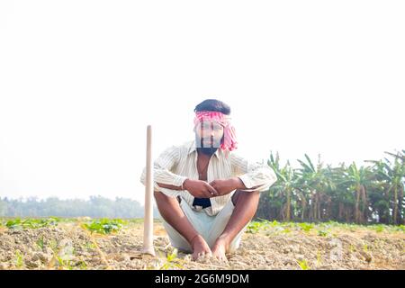 Indian Young Farmer Sitting on his agriculture field Stock Photo