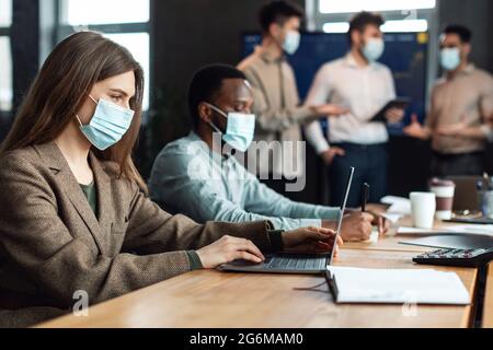 Colleagues having meeting in boardroom, working on project using pc Stock Photo