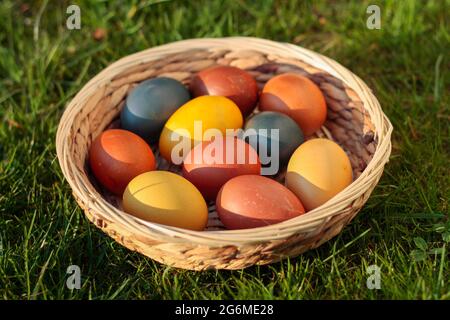 Easter eggs, coloured hen eggs in a wicker basket Stock Photo