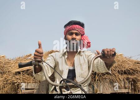 Young Adult man driving machine rickshaw  showing thumbs up sign Stock Photo