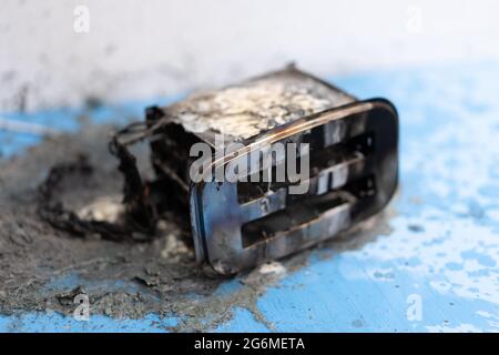 Toaster after fire. Household electrical appliance fire hazard. Overload. Short circuit. Carelessness. Safety in home. Danger home inflammation Insura Stock Photo