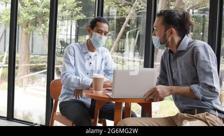 Two start up Asian businessman meeting, planning and discussing in business on laptop in café Stock Photo
