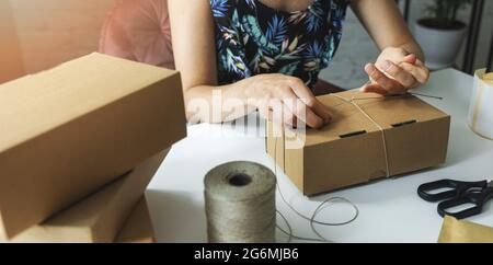 small online business owner packing parcel box at home to deliver product to customer. banner Stock Photo