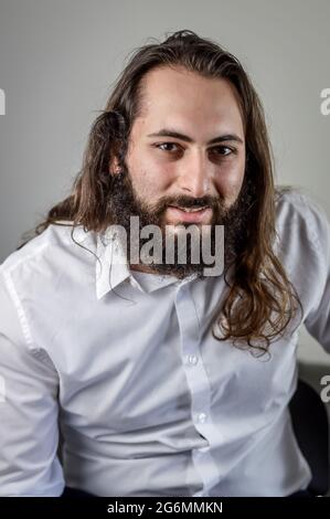 portrait of a young middle eastern businessman with beard and long hair Stock Photo