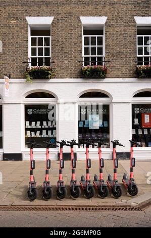 Electric hire scooters parked outside the Cambridge University Press Bookshop in Cambridge, England. Stock Photo