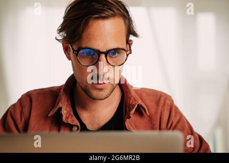 Close up caucasian male working from home on laptop Stock Photo