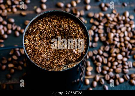Coarsely Ground Coffee Beans in a Grinder: Coffee grounds in an electric coffee grinder Stock Photo