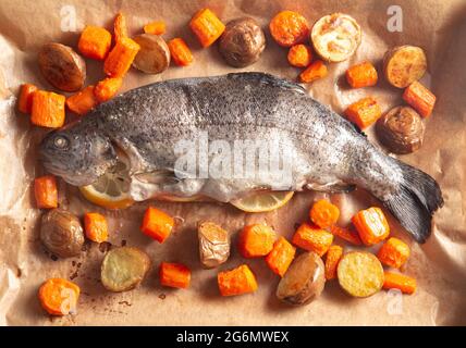 A Whole Baked Rainbow Trout with Roasted Root Vegetables Stock Photo