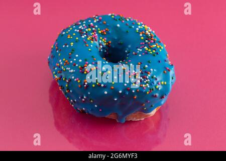A Blue Glazed Donut with Rainbow Sprinkles on Top Stock Photo