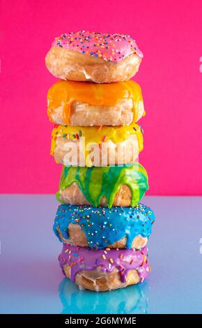 A Tower of Rainbow Colored Glazed Donuts Stock Photo