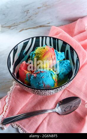 Tricolor superman icecream in zebra stripe bowl featuring blue moon vanilla and black cherry flavors Stock Photo