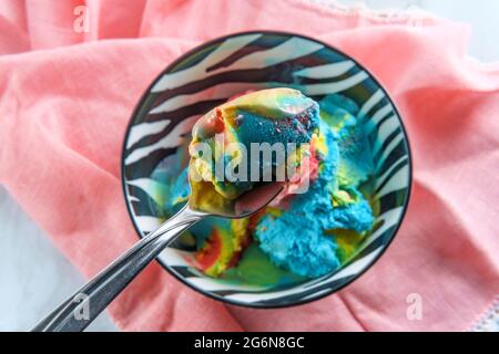 Tricolor superman icecream in zebra stripe bowl featuring blue moon vanilla and black cherry flavors Stock Photo
