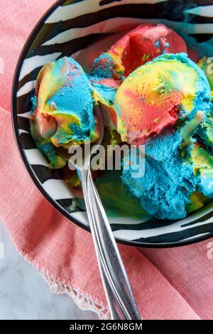Tricolor superman icecream in zebra stripe bowl featuring blue moon vanilla and black cherry flavors Stock Photo