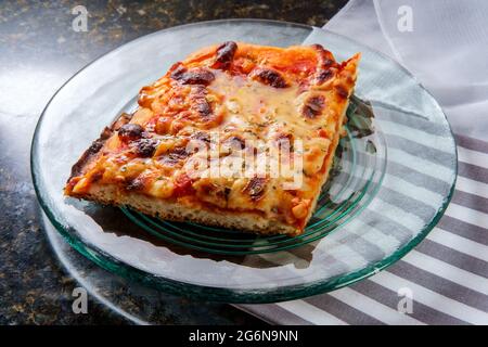 Obe slice of Sicilian thick crust plain pizza with crispy cheese Stock
