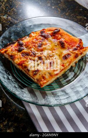 Obe slice of Sicilian thick crust plain pizza with crispy cheese Stock