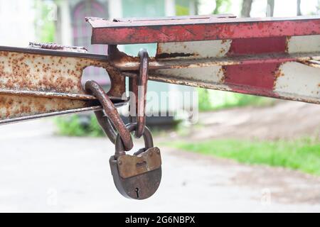 Big old lock on the door. A rusty lock closes the house. Background of antiquities. Reliable property protection. Metal products from steel. Stock Photo