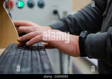 The process of programming a CNC machine. Entering data into a computer controlled machine, starting CNC engraving, control screen. Furniture manufact Stock Photo