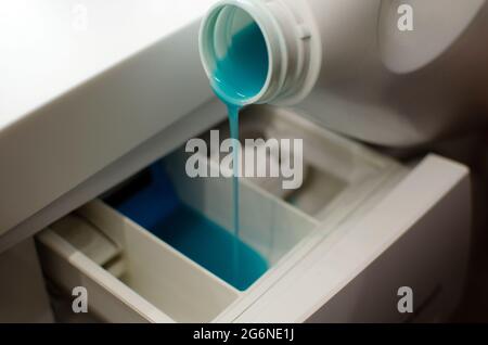 pour gel for washing into washing machine, white bottle with blue gel for washing clothes, liquid detergent. Stock Photo