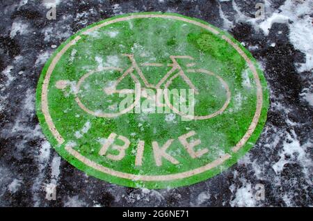 Cycle path in the snow. Riding bicycles in winter. A bright green sign for a bike path. Asphalt covered with snow and ice the road after a snowfall Stock Photo Alamy