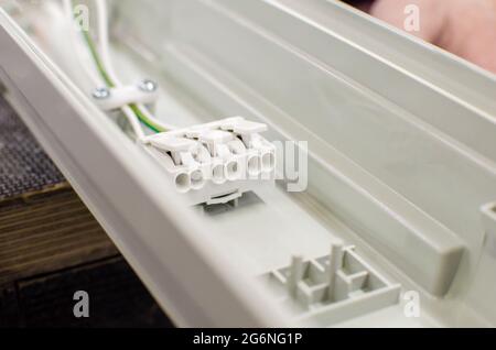 New ceiling mounted fluorescent lamp. Repair and service concept. Electrical plug for connection Stock Photo