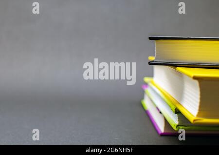 A simple composition of many hardback books on a black background. Back to school. Education concept. Copy space Stock Photo