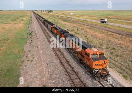 Roggen, Colorado - A Burlington Northern Santa Fe freight train carrying coal alongside Interstate-76 east of Denver. Stock Photo