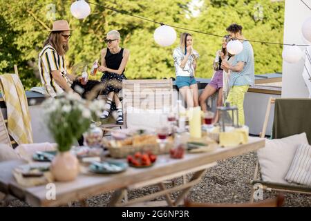 Young stylish friends having a festive dinner on the roof terrace Stock Photo