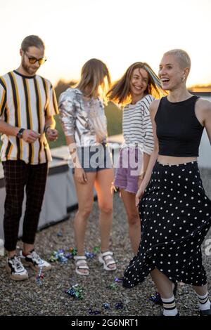 Friends dancing at rooftop terrace on sunset Stock Photo
