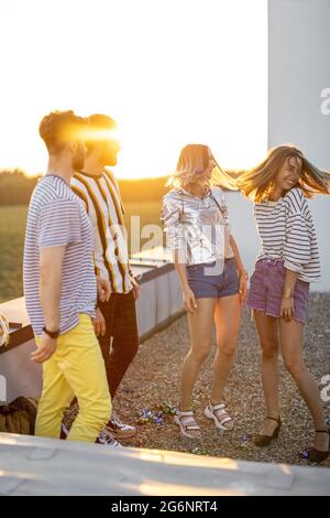 Friends dancing at rooftop terrace on sunset Stock Photo