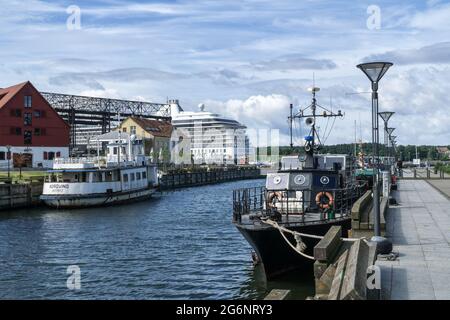 KLAIPEDA, LITHUANIA, JULY 10, 2016: Boats moored in river port, big luxury cruiser in background. Stock Photo